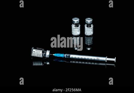 PRAGUE, CZE - 10 mars 2021. Ampoules de vaccin contre le virus du SRAS COVID-19. Vaccin mRNA de COMIRNATY sur fond noir. Seringue avec vaccin COMIRNATY contre S. Banque D'Images