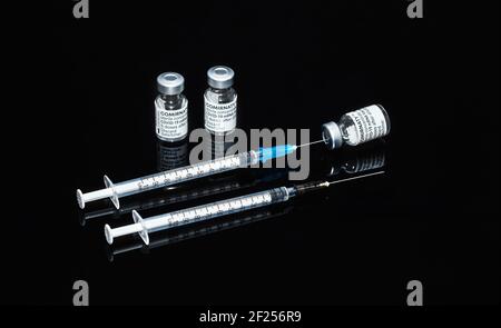 PRAGUE, CZE - 10 mars 2021. Ampoules de vaccin contre le virus du SRAS COVID-19. Vaccin mRNA de COMIRNATY sur fond noir. Seringue avec vaccin COMIRNATY contre S. Banque D'Images