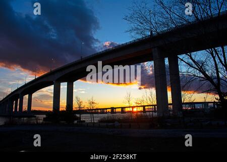 Pont de la victoire au-dessus de la rivière Raritan par une journée d'hiver nuageux, avec le soleil couchant illuminant l'horizon -04 Banque D'Images