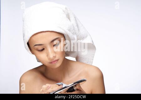 femme d'apparence asiatique regardant dans le miroir soin de peau soins de santé Banque D'Images