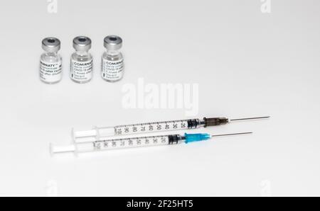 PRAGUE, CZE - 10 mars 2021. Ampoules de vaccin contre le virus du SRAS COVID-19. Vaccin à ARNm COMIRNATY sur fond blanc. Seringue avec vaccin COMIRNATY contre S. Banque D'Images