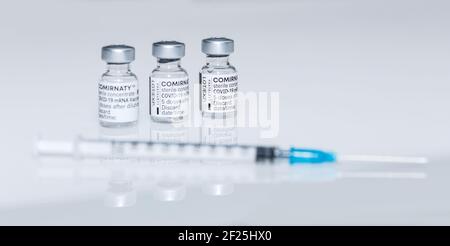 PRAGUE, CZE - 10 mars 2021. Ampoules de vaccin contre le virus du SRAS COVID-19. Vaccin à ARNm COMIRNATY sur fond blanc. Seringue avec vaccin COMIRNATY contre S. Banque D'Images