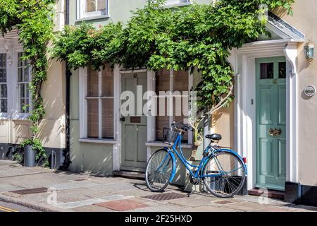 Un vélo bleu penchée contre une maison à Sandwich Kent Banque D'Images