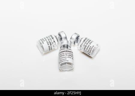 PRAGUE, CZE - 10 mars 2021. Ampoules de vaccin contre le virus du SRAS COVID-19. Vaccin à ARNm COMIRNATY sur fond blanc. Seringue avec vaccin COMIRNATY contre S. Banque D'Images