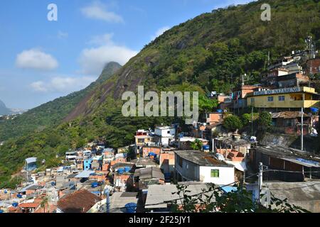 Maisons typiques de favela à flanc de colline et église locale dans le quartier de Santa Marta à Rio de Janeiro, Brésil. Banque D'Images