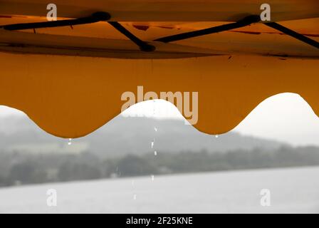 La pluie s'égoutte des bâillements lors d'une excursion en bateau sur le Loch Lomond, en Écosse, par une journée humide Banque D'Images