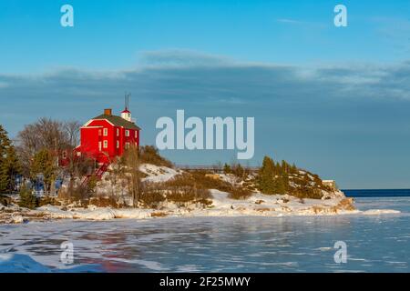 Marquette Harbour Lighthouse rouge vif en février à Marquette, Michigan, États-Unis Banque D'Images