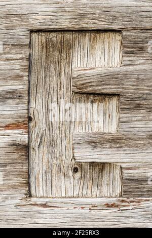 La lettre E a scié du bois abîmé Banque D'Images