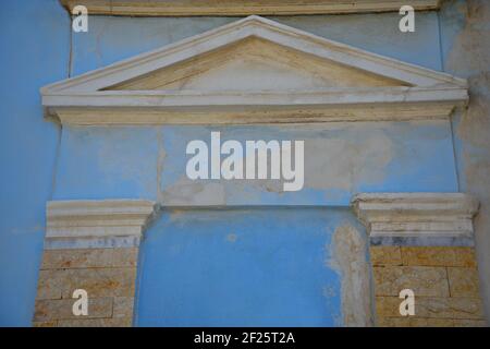 Façade en plâtre blanc de style néoclassique sur un mur en stuc bleu clair dans la ville historique de Lavrion, Attica Grèce. Banque D'Images