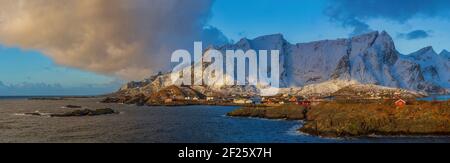 La lumière magique du soleil levant illumine le pittoresque village de pêcheurs de Reine, avec des sommets enneigés en arrière-plan, Lofoten, Banque D'Images