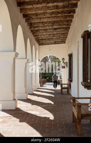 Oceanside, Californie États-Unis - 5 mars 2021 : couloir ombragé avec bancs, arches et poutres apparentes à Mission San Luis Rey Banque D'Images