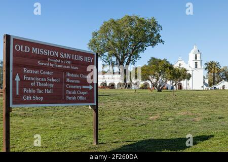 Oceanside, Californie États-Unis - 5 mars 2021 : panneau d'entrée avec indications pour la vieille Mission San Luis Rey, église, et bâtiments en arrière-plan Banque D'Images