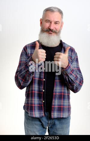 Studio portrait mature barbu homme habillé de vêtements décontractés montre pouces vers le haut, concept réussi, fond blanc Banque D'Images