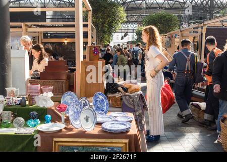 Liverpool Street, Londres, Royaume-Uni,- 21 septembre 2020, UNE femme examine des articles vintage sur le comptoir. Marché aux antiquités de Spitalfields Banque D'Images