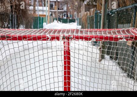 Gros plan sur un but de hockey et petit anneau de glace fait maison pour les enfants dans une allée de Montréal, les voisins de la famille partagent l'espace de jeu, la culture locale Banque D'Images