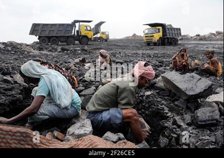 INDE, Jharkhand, Dhanbad Jharia, site d'extraction de charbon BCCL, charge lourde de camions Volvo, charriot, les gens collectent illégalement du charbon du champ de charbon à vendre sur le marché pour les moyens de subsistance / INDIEN, Dhanbad Jharia, BCCL Kohletagebau, Volvo Kipper laden Abraum ab, Menschen sammeln le Kohzum auf Verdem Markzum Banque D'Images