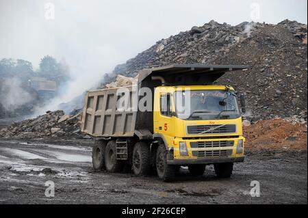 INDE, Jharkhand, Dhanbad Jharia, site d'extraction de charbon BCCL, camion poids lourd de Volvo, fumée de combustion de champs de charbon / INDIEN, Dhanbad Jharia, BCTL Kohletagebau, Volvo Kladen Abraum ab, brennende Kohleflöze Banque D'Images