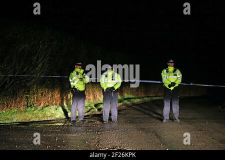 Des officiers de la police métropolitaine se tiennent à un cordon de police près d'une zone boisée d'Ashford dans le Kent, après la découverte de restes humains dans la chasse à la femme disparue Sarah Everard. La police met a annoncé mercredi qu'un agent de protection diplomatique détenu pour la disparition de Sarah Everard avait été arrêté pour meurtre. Date de la photo: Mercredi 10 mars 2021. Banque D'Images