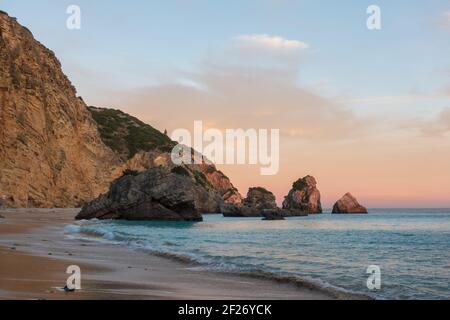Ribeiro do Cavalo Paradise Beach dans le Parc naturel d'Arrabida à Sesimbra au coucher du soleil, Portugal Banque D'Images