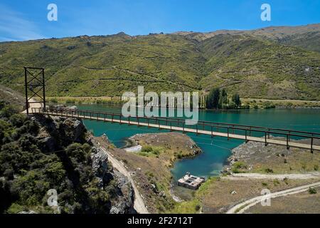 Pont suspendu Hugo sur le sentier du cycle du lac Dunstan et le lac Dunstan, près de Cromwell, Central Otago, South Island, Nouvelle-Zélande Banque D'Images