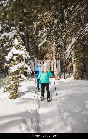 Deux aînés actifs et en bonne santé qui font de la raquette dans le Wyoming. Paysage hivernal. Amis randonnée en raquettes dans la neige ensemble. Regarder l'appareil photo. Banque D'Images