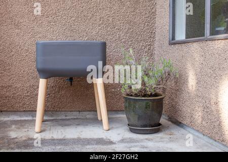 Un système de vermicomposter (worm composter) est installé sur un balcon d'appartement avec d'autres jardinières. Les vers mangent des restes de nourriture et produisent des moulages de vers et Banque D'Images