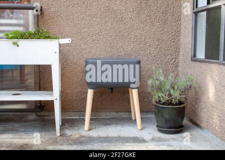 Un système de vermicomposter (worm composter) est installé sur un balcon d'appartement avec d'autres jardinières. Les vers mangent des restes de nourriture et produisent des moulages de vers et Banque D'Images