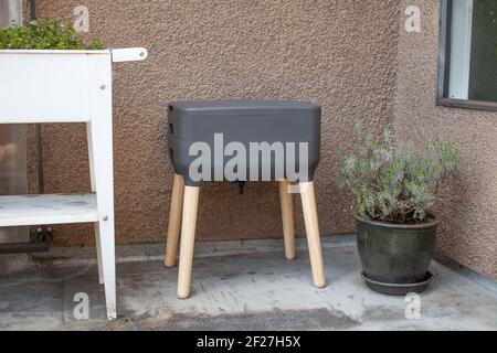 Un système de vermicomposter (worm composter) est installé sur un balcon d'appartement avec d'autres jardinières. Les vers mangent des restes de nourriture et produisent des moulages de vers et Banque D'Images