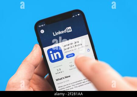 Kharkov, Ukraine - 9 mars 2021 : l'homme utilise l'application LinkedIn et cherche un emploi, recherche nouvelle photo de concept d'emploi Banque D'Images