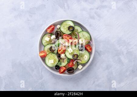 Salade grecque, prise du dessus. Salade fraîche avec feta, tomates, concombres, oignons et olives Banque D'Images