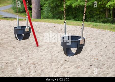 Balançoires dans le parc à l'aire de jeux en été sans personnes Banque D'Images