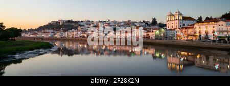 Vue panoramique sur Alcacer do Sal cityscape depuis l'autre côté de la rivière Sado au coucher du soleil Banque D'Images