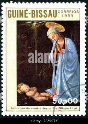 Un timbre imprimé en Guinée-Bissau, a montré la peinture de FRA Filippo Lippi - Madonna et l'enfant et l'adoration des Mages, vers 1989 Banque D'Images