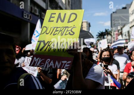 Un activiste tient un écriteau alors que divers groupes militants appellent à l'éviction du président Rodrigo Duterte près du Palais Malacanang à Manille, aux Philippines. Banque D'Images