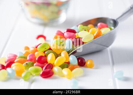 Palets de gelée colorés doux dans une cuillère sur une table blanche. Banque D'Images