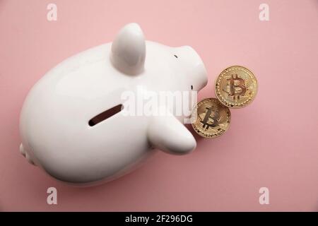les pièces de crypto-monnaie bitcoin avec une banque de porc blanche économisant de l'argent boîte Banque D'Images