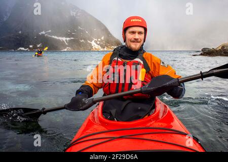 Kayak à Reine, Moskenes, Île de Moskenesøya, îles Lofoten, Norvège. Paysage avec le pic d'Olstiden. Banque D'Images