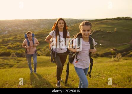 Famille avec sacs à dos en voyage touristique dans les montagnes. Jolie fille avec des parents campant dans la nature pendant les vacances d'été Banque D'Images