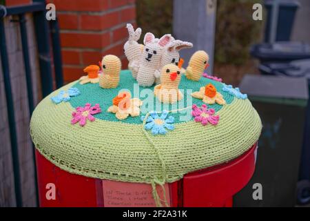 Rouge, boîte postale, boîte postale, crochetée, Royal Mail, Chapeaux en laine, housses, tricotés à la main, boîtes à colonnes, Lincoln City, Créatures marines, lapins de Pâques, fleurs. Banque D'Images