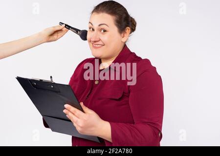 Les femmes d'affaires signe des documents et la main du maître poudre son visage. Emploi et maquillage sur fond blanc. Banque D'Images