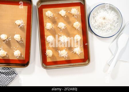 Pose à plat. La pâte non cuite s'étale sur la plaque de cuisson pour cuire des biscuits à la noix de coco. Banque D'Images