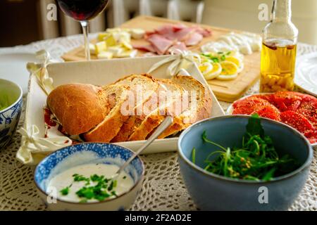 Un pain coupé en tranches. Un petit déjeuner continental sain composé de pain maison et d'un pain aux légumes, au fromage et aux œufs, à l'olive et au jambon à base de Banque D'Images