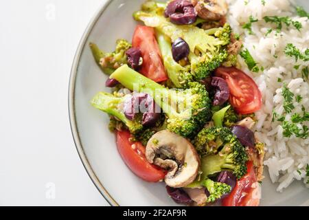 Légumes cuits au four de brocoli, champignons, tomates et olives avec riz et persil garnir, cuisine saine avec des ingrédients frais, gros plan par dessus Banque D'Images