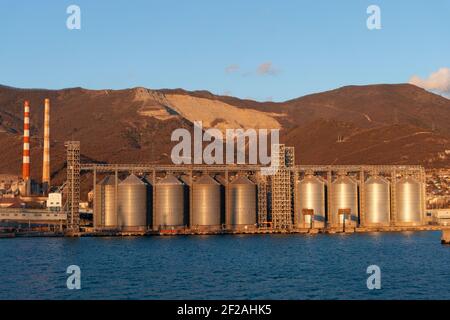 citernes pour le stockage du grain dans le port au bord de la mer en toile de fond de la montagne Banque D'Images