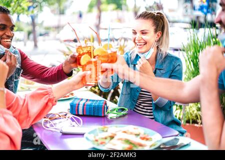 Les jeunes boivent des spritz au bar à cocktails portant des masques - Nouveau concept d'amitié normale avec des amis qui s'amusent ensemble toaster les boissons Banque D'Images