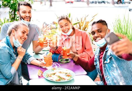 Des gens multiculturels prenant le selfie avec des masques ouverts au cocktail Bar - Nouveau concept de style de vie normal avec de jeunes amis amuse-toi bien Banque D'Images