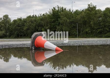 Cône de route renversé - réflexion dans le bas de la porte, cône de circulation renversé dans le bas de l'eau Banque D'Images