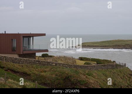 Maison moderne sur le bord de la falaise en Irlande donnant sur une petite île sur l'océan Atlantique, architecture moderne, verre et acier, sur le bord Banque D'Images