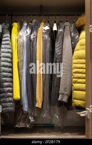 Un petit dressing dans l'appartement de l'homme. Les vêtements tendance pour hommes de couleurs neutres sont bien accrochés aux cintres. Mode concept, appartement, maison d Banque D'Images