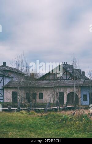 Un pont à travers l'étang en face des maisons de l'ancienne cité médiévale. Ciel sombre avec nuages sur les vieilles maisons. Banque D'Images